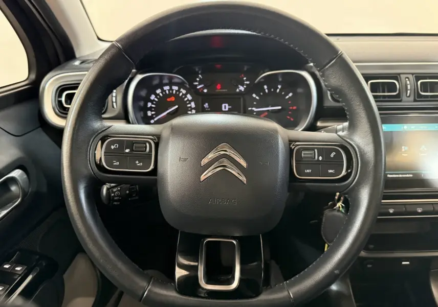 Volant cuir noir de Citroën C3 2019 vu de face, avec commandes intégrées et tableau de bord lumineux.