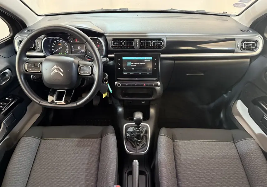 Intérieur de Citroën C3 gris clair, vue frontale du tableau de bord avec écran tactile et volant multifonctions.