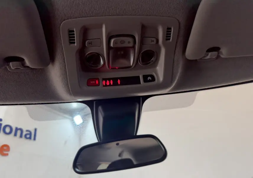 Vue intérieure du plafonnier et rétroviseur central de la Citroën C3 gris clair de 2019 avec commandes éclairage et SOS.