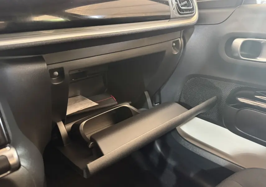 Intérieur de la Citroën C3 2019 gris clair, vue sur la boîte à gants ouverte côté passager avec tableau de bord noir.
