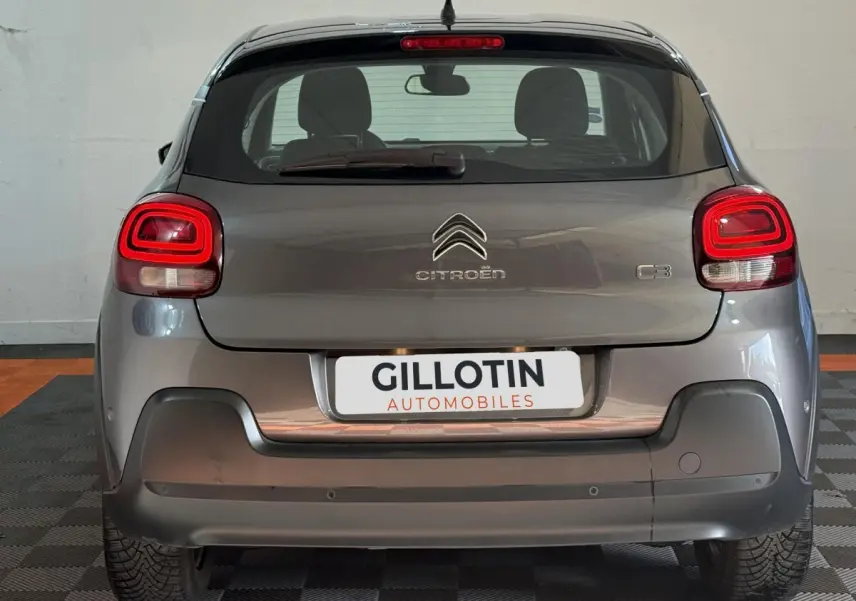 Vue arrière d'une Citroën C3 gris clair avec feux LED et logo centré sur le hayon dans un garage.