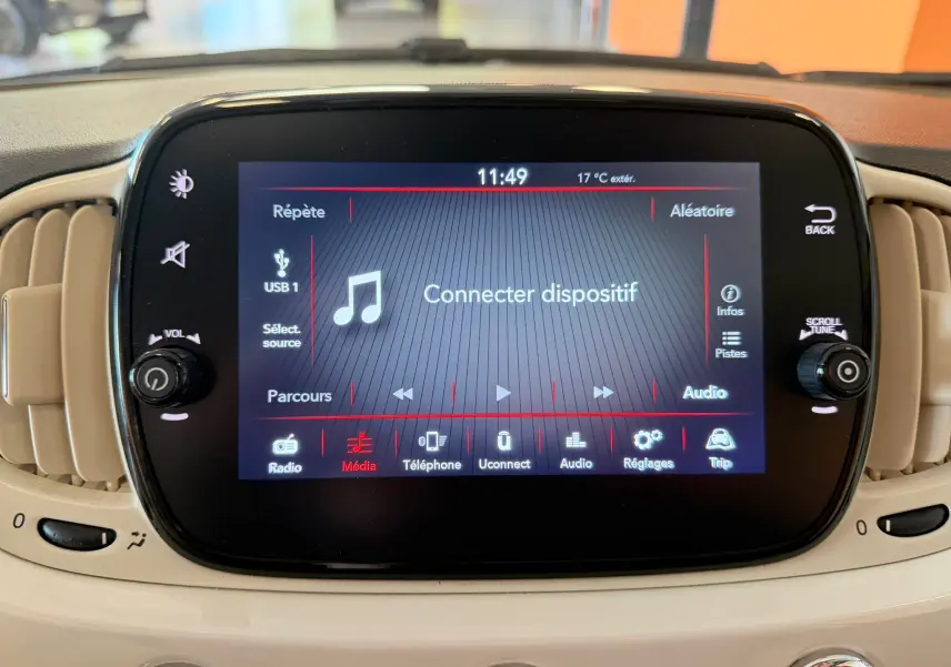 Écran tactile central du tableau de bord beige d'une Fiat 500 blanche, affichant le menu média avec option "Connecter dispositif".