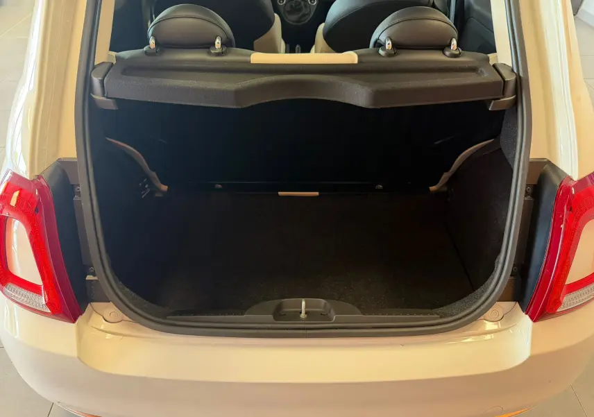 Coffre ouvert vu de l'arrière d'une Fiat 500 blanche Bossa Nova, montrant l'espace de chargement et les appuis-tête arrière.