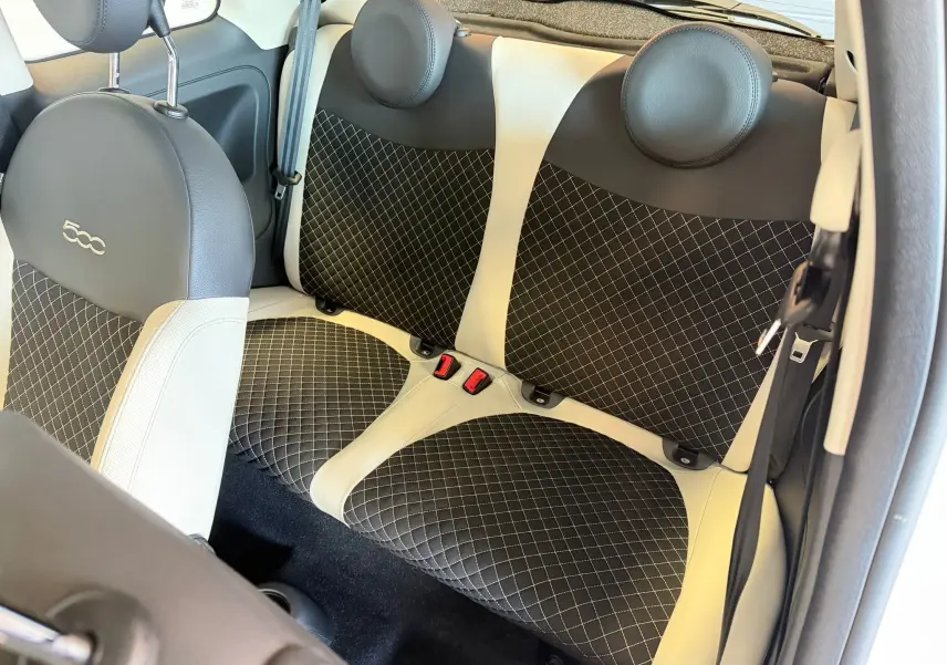 Vue intérieure arrière du Fiat 500 2022 en Bossa Nova White, sièges bicolores noirs et blancs avec surpiqûres croisées.