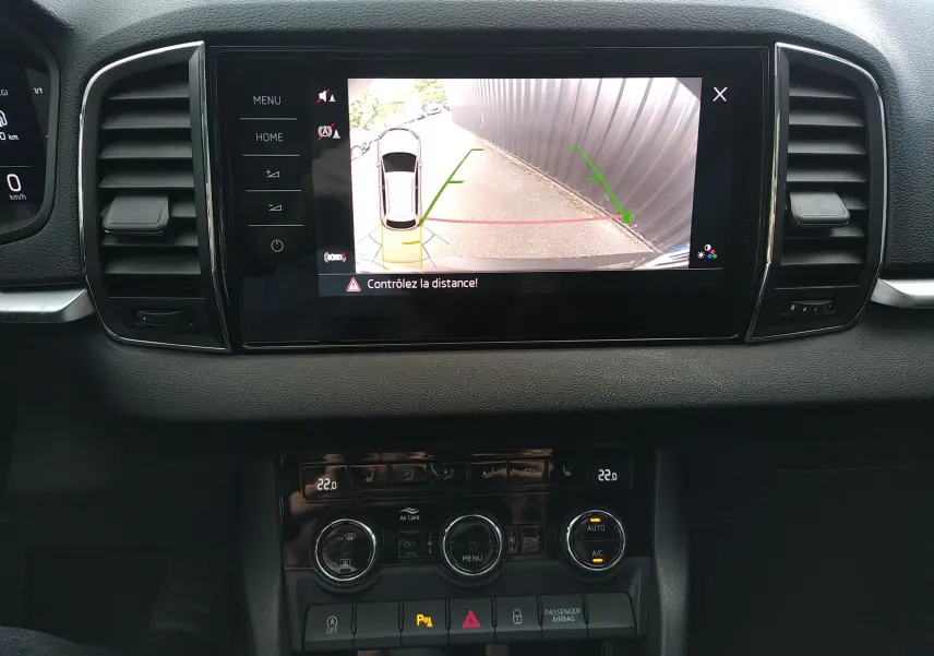 Vue intérieure du tableau de bord du Skoda Karoq gris 2022, écran central affichant la caméra de recul avec guidage.