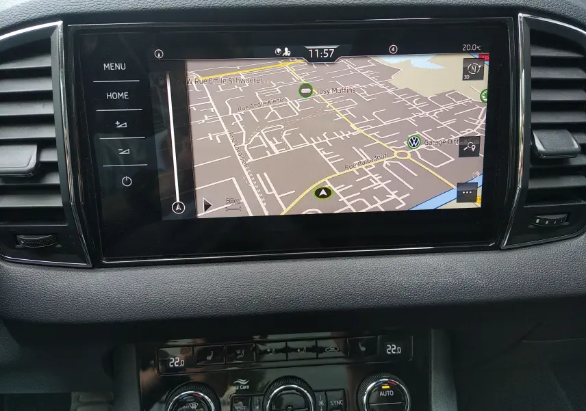 Écran tactile central avec navigation GPS dans l’habitacle d’un Skoda Karoq gris, vue rapprochée du tableau de bord.