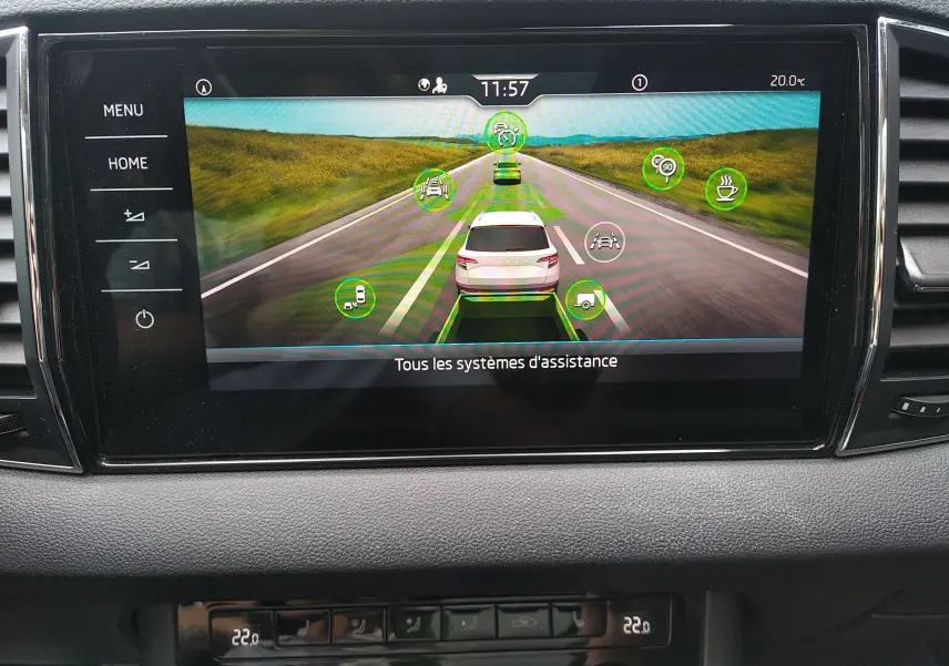 Écran central du Skoda Karoq gris montrant l'interface des systèmes d'assistance à la conduite en vue arrière virtuelle.