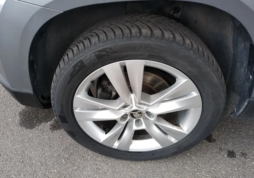 Gros plan sur la roue avant gauche grise d'un Skoda Karoq 2.0 TDI 150ch 4x4 DSG7 Style, jante alliage 18 pouces.