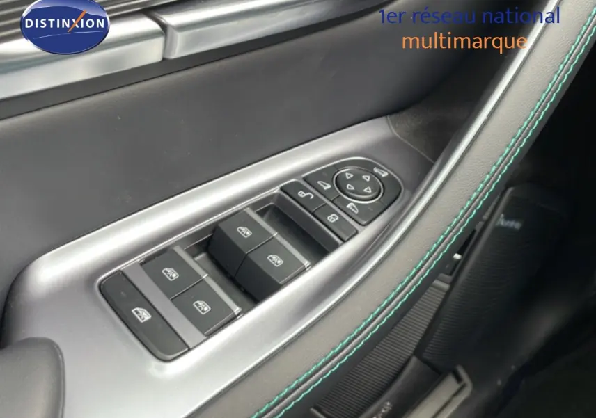 Gros plan sur les commandes des vitres et rétroviseurs côté conducteur du BYD SEAL U 2026 en intérieur noir avec surpiqûres bleues.
