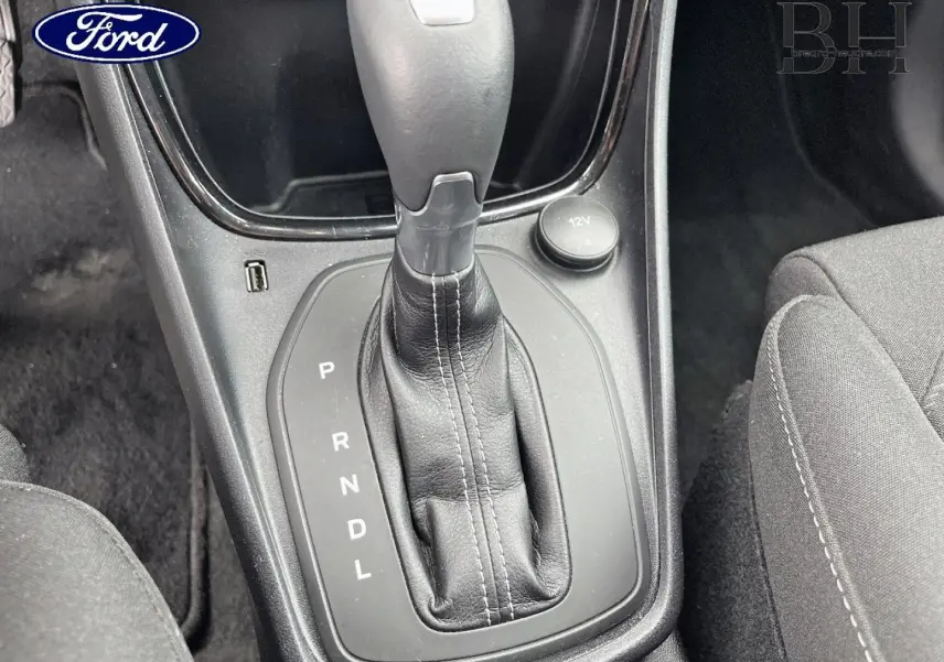 Gros plan sur la commande de la boîte automatique noire du Ford Puma 2023, avec tissu de siège gris visible à droite.