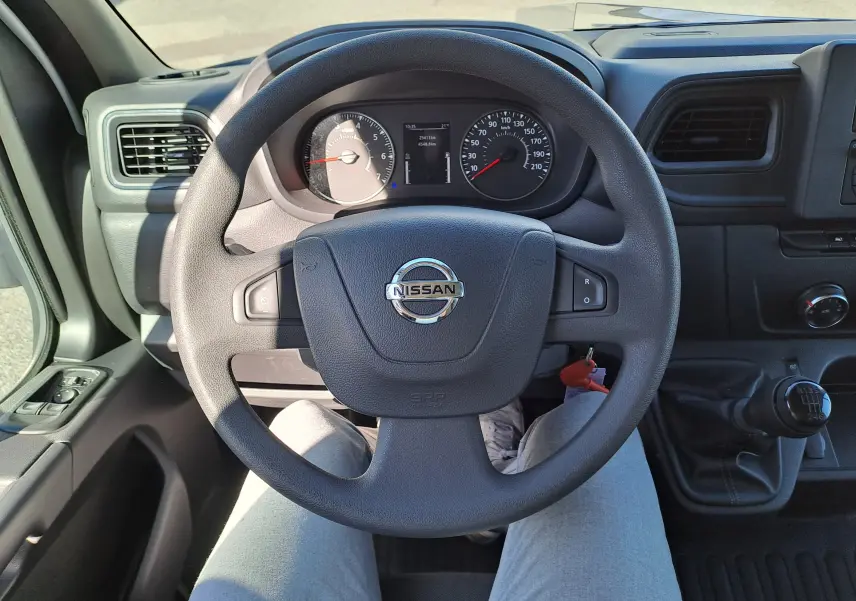 Vue intérieure centrée sur le volant Nissan d'un Interstar Chassis Cabine 2024 avec boîte manuelle et tableau de bord visible.