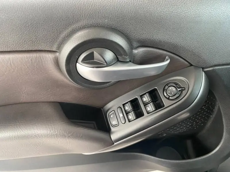 Poignée de porte intérieure côté gauche en plastique noir et argent avec commandes électriques de la FIAT 500X noire 2018.