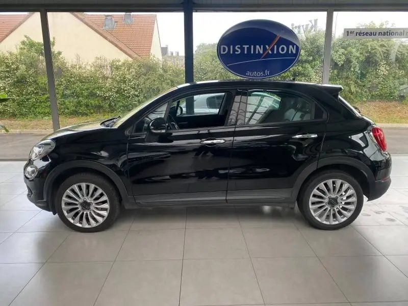 Profil latéral droit d'un FIAT 500X noir 2018 avec jantes alliage et rétroviseurs électriques dans un showroom.