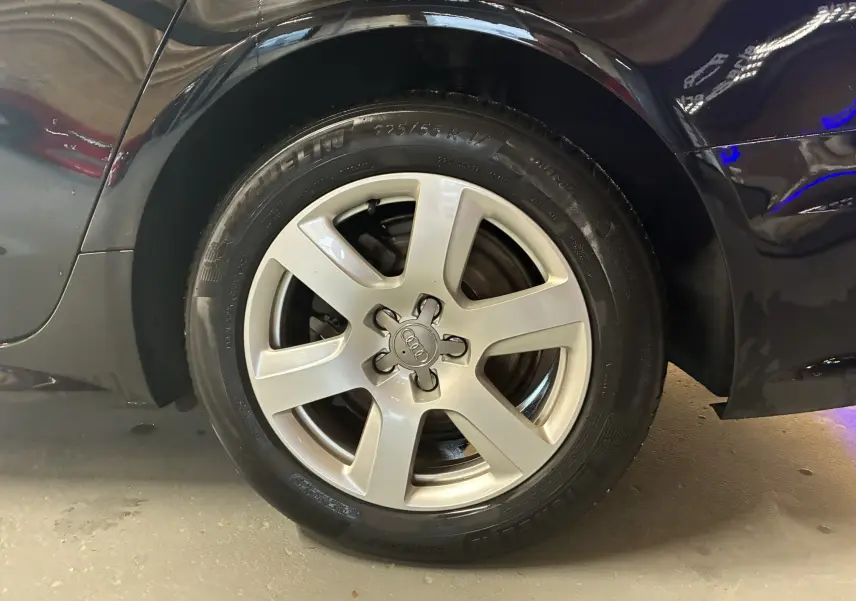 Gros plan sur la roue arrière droite noire d'une Audi A6 Avant 2.0 TDI 2017 avec jante alu cinq branches.