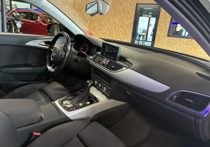 Intérieur noir de l'Audi A6 Avant 2017, vue côté conducteur montrant tableau de bord et console centrale moderne.
