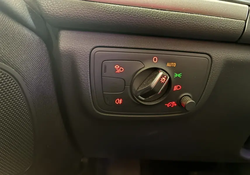 Gros plan sur le panneau de commande des phares noir à gauche du tableau de bord de l'Audi A6 Avant 2017.