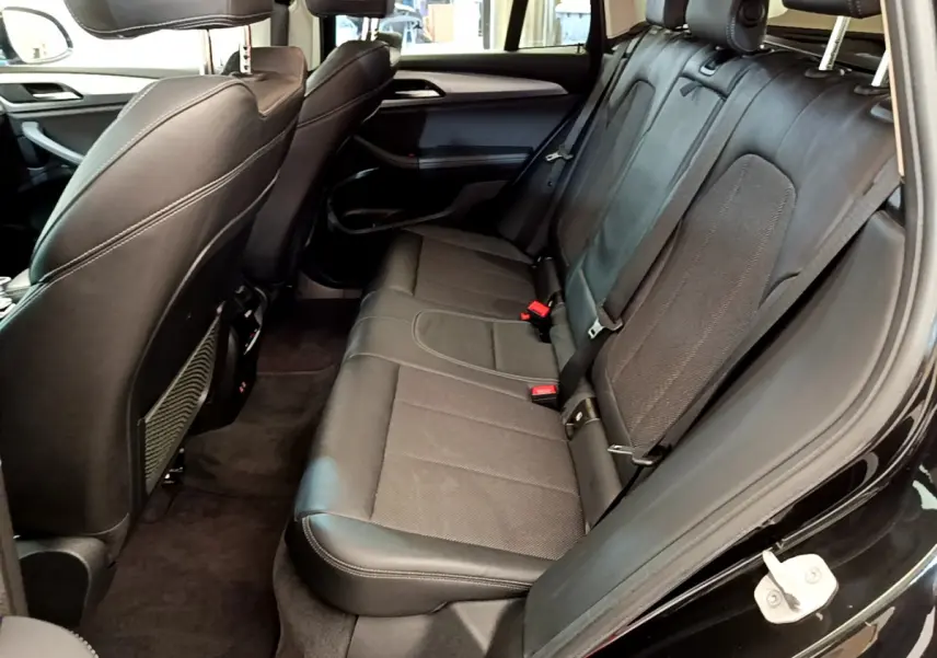 Vue intérieure côté droit sur la banquette arrière en cuir noir du BMW X3 xDrive20d Lounge 2020.