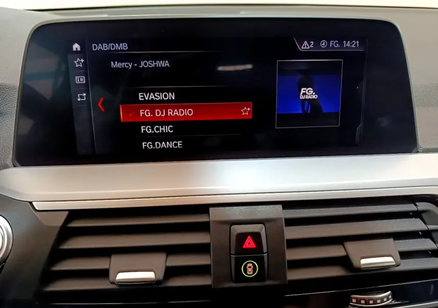 Écran central du tableau de bord du BMW X3 noir 2020 affichant la sélection radio FG. DJ RADIO en intérieur moderne