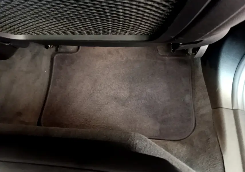 Tapis de sol gris foncé côté passager arrière d'un BMW X3 xDrive20d 2020, avec filet de rangement sous le siège.