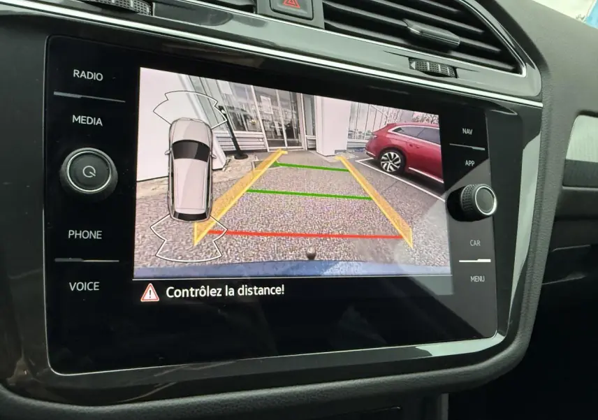 Vue rapprochée de l'écran de la caméra de recul du Volkswagen Tiguan 2022 avec affichage des lignes de guidage colorées.
