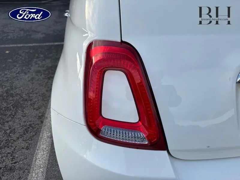 Gros plan sur le feu arrière gauche rouge d'une Fiat 500 blanche Bossa Nova Pastel, avec partie de la carrosserie visible.