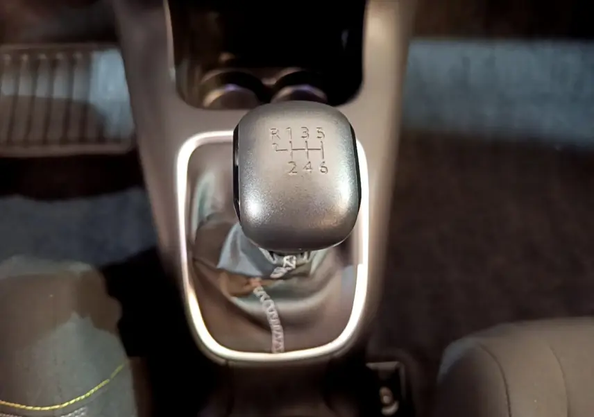 Le levier de vitesses manuel gris de la CITROEN C3 blanche, vu de dessus au centre de l'habitacle.