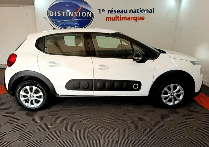 Profil côté gauche d'une Citroën C3 blanche de 2019 avec protections latérales noires caractéristiques et jantes alliage.