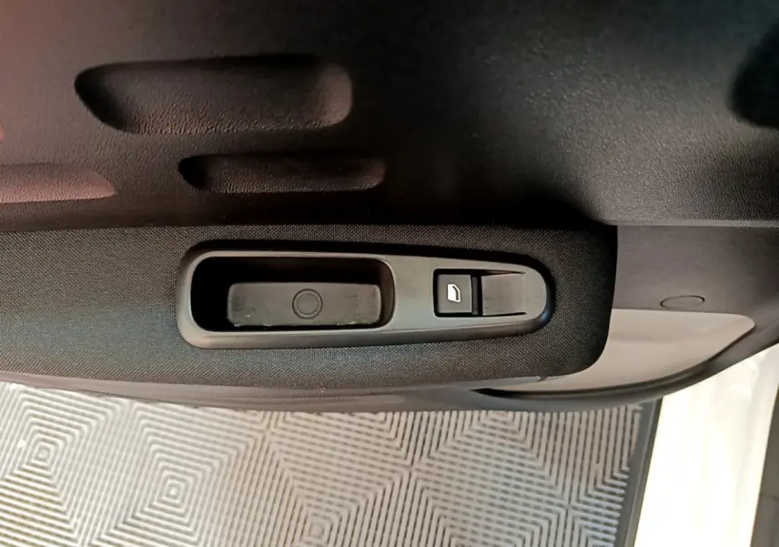 Poignée intérieure de porte côté gauche de la Citroën C3 blanche, avec bouton de verrouillage visible.