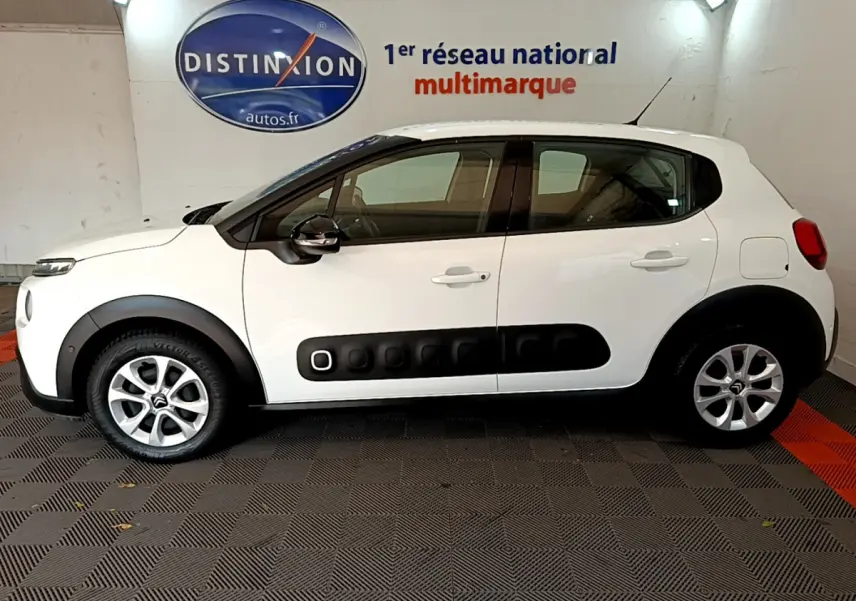 Profil côté gauche d'une Citroën C3 blanche 2019 avec protections noires caractéristiques et jantes alliage.