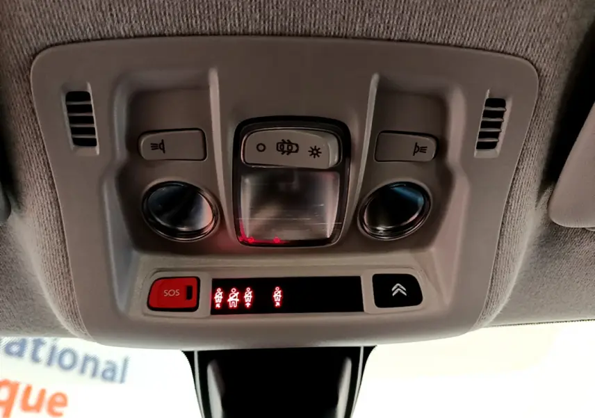 Vue en gros plan du plafonnier intérieur gris avec boutons d'éclairage et alerte ceintures de la Citroën C3 blanche 2019.