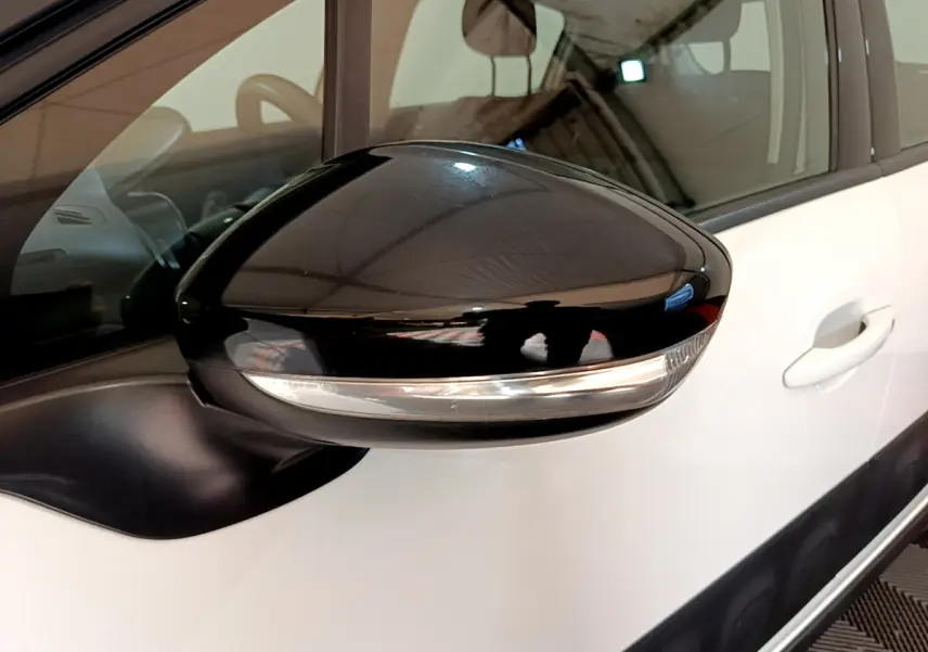 Rétroviseur noir avec clignotant intégré côté gauche d'une Citroën C3 blanche, vue rapprochée du côté conducteur.
