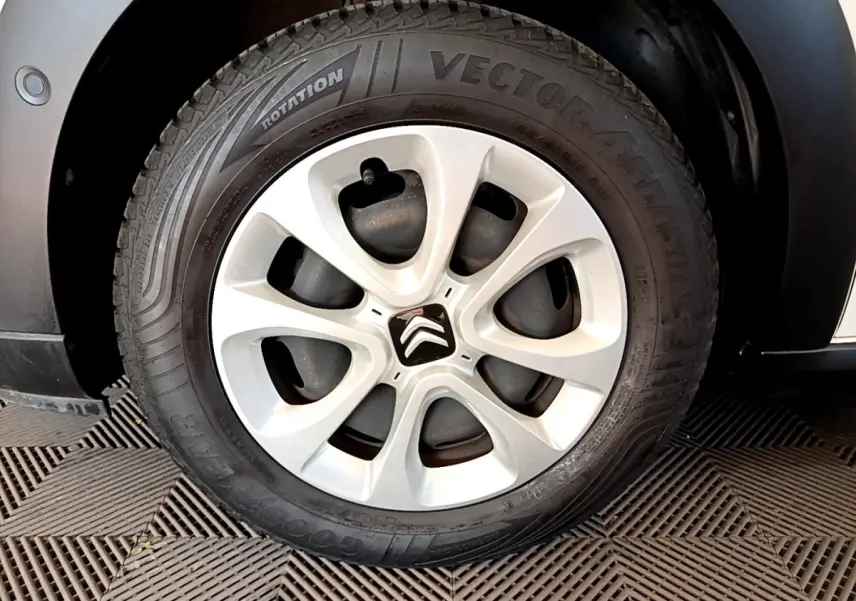 Gros plan sur la roue avant droite d'une Citroën C3 blanche de 2019 avec jante acier et pneu Goodyear Vector 4Seasons.
