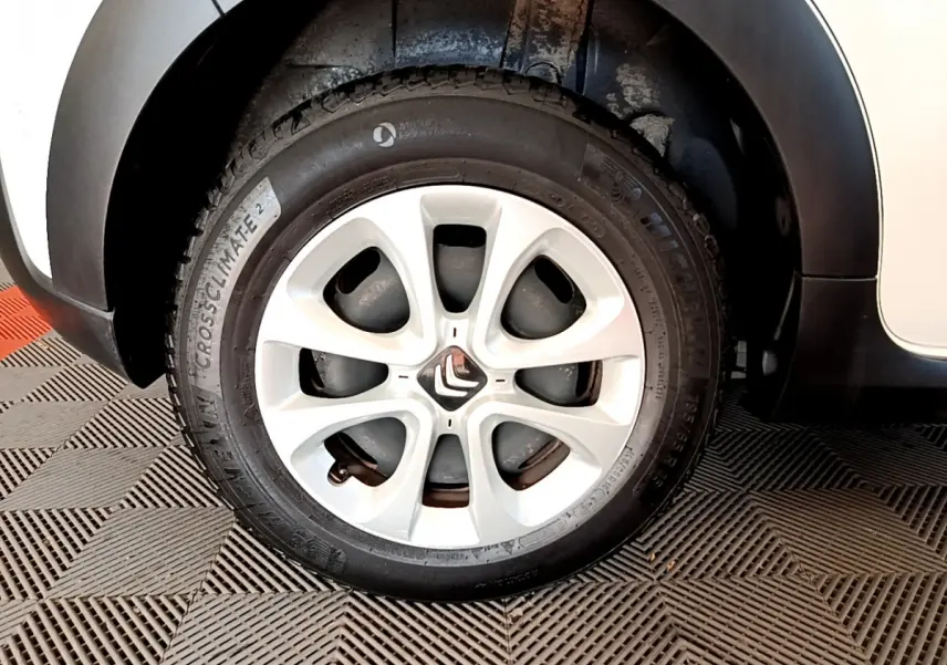 Gros plan sur la roue avant droite blanche d'une Citroën C3 2019, avec jante alliage et logo Citroën central.