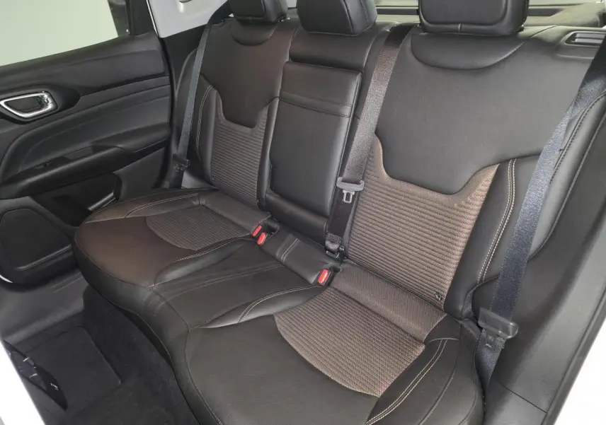 Vue intérieure côté droit sur la banquette arrière noire et bronze du Jeep Compass 2024 avec ceinture de sécurité visible.