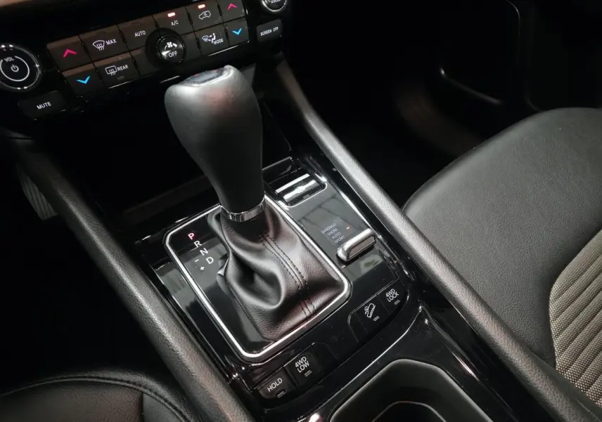 Gros plan sur la console centrale noire avec levier de vitesses automatique et commandes 4WD du Jeep Compass blanc 2024.