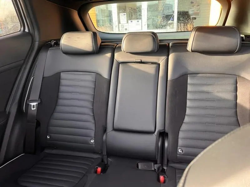 Vue arrière intérieure des sièges noirs en cuir et suède du Kia Sportage GT-Line Premium 2022, avec appuie-têtes et ceintures.