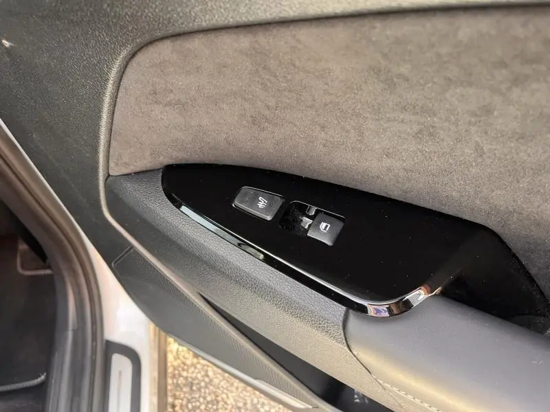 Détail des commandes de verrouillage et de réglage des vitres sur la porte côté conducteur du KIA Sportage blanc nacré 2022.