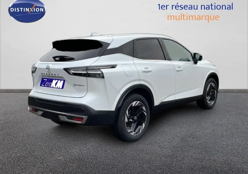 Vue 3/4 arrière droite d'un Nissan Qashqai blanc nacré métal avec jantes noires et vitres teintées.