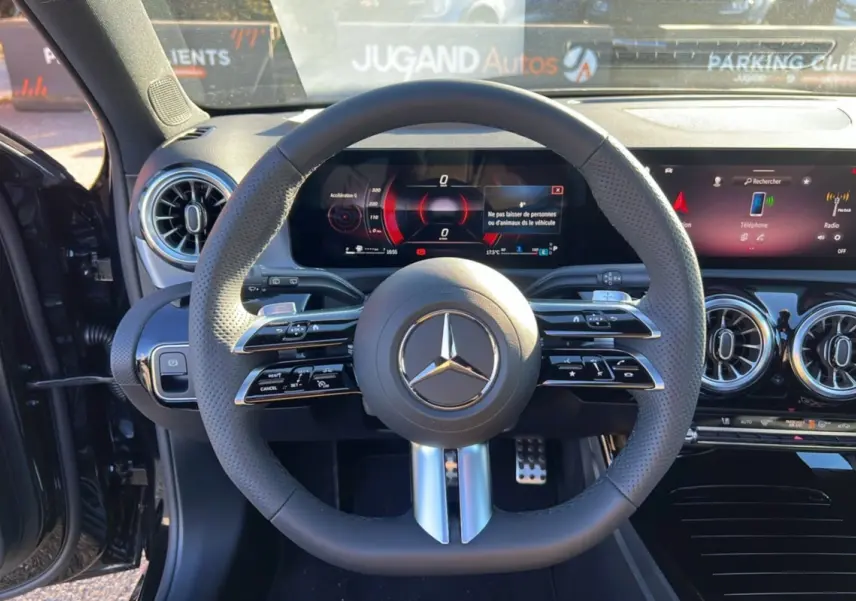 Vue intérieure centrée sur le volant cuir multifonctions de la Mercedes Classe A 200D BVA Exclusive Design noir cosmos.