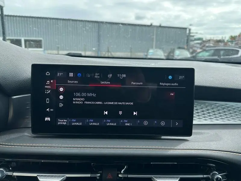 Écran tactile central affichant la radio FM dans l’habitacle d’une Alfa Romeo Tonale blanc Monterosa pastel.