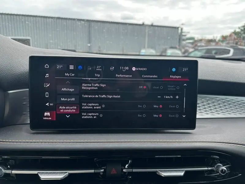 Écran tactile central affichant les réglages d’aide à la conduite dans l’Alfa Romeo Tonale blanc, vue intérieure frontale.