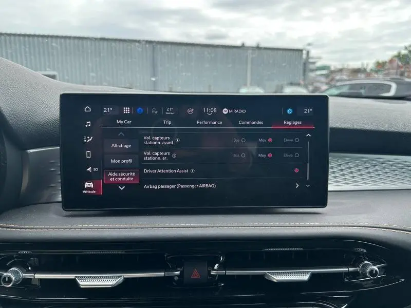 Écran tactile central affichant les réglages du véhicule dans l'habitacle de l'Alfa Romeo Tonale blanc, vue de face.