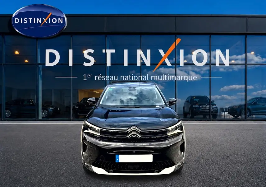Vue frontale d'un Citroën C5 Aircross hybride rechargeable noir, avec calandre distinctive et phares LED allumés.