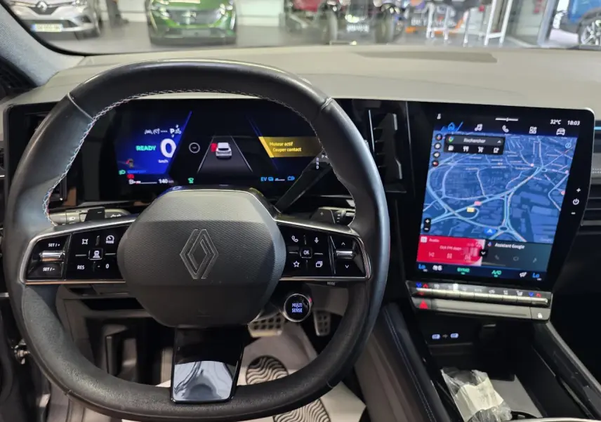 Vue intérieure centrée sur le volant et tableau de bord numérique du Renault Austral gris foncé avec écran tactile vertical.