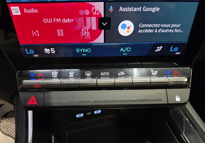 Gros plan sur la console centrale du Renault Austral gris foncé, avec commandes climatisation et écran tactile visible.