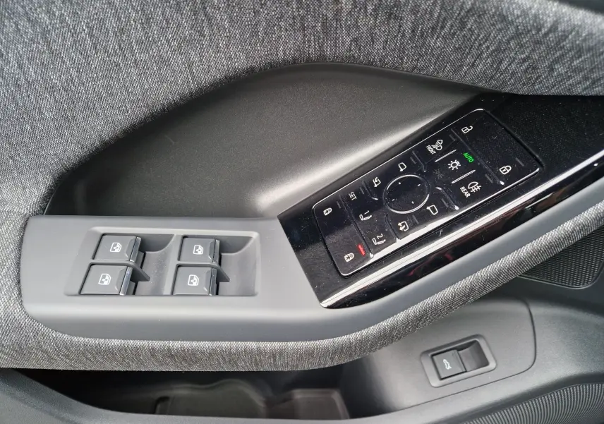 Panneau de commandes côté gauche avec boutons de vitres et réglages des rétroviseurs sur Audi Q6 e-tron gris Manhattan.
