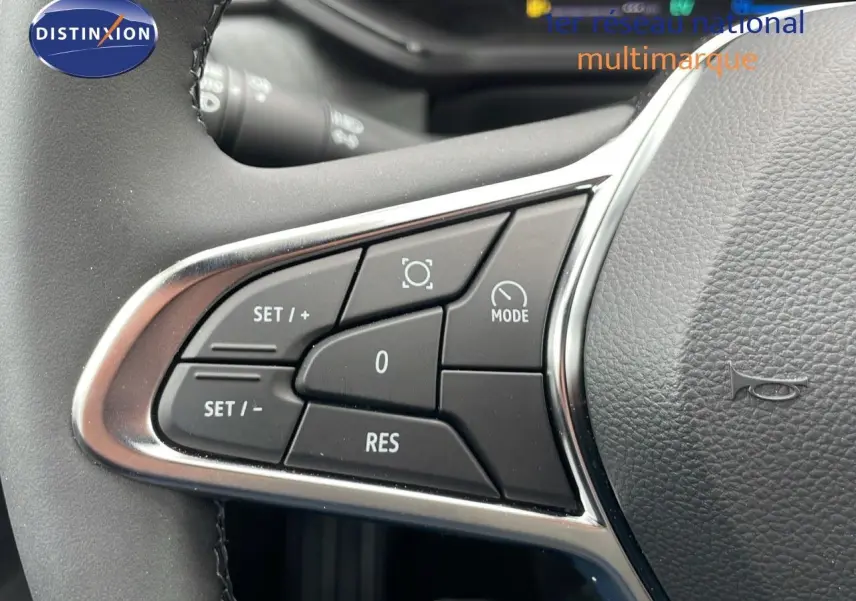Gros plan sur les commandes du volant du Renault Captur E-Tech hybride, boutons noirs encadrés de chrome.