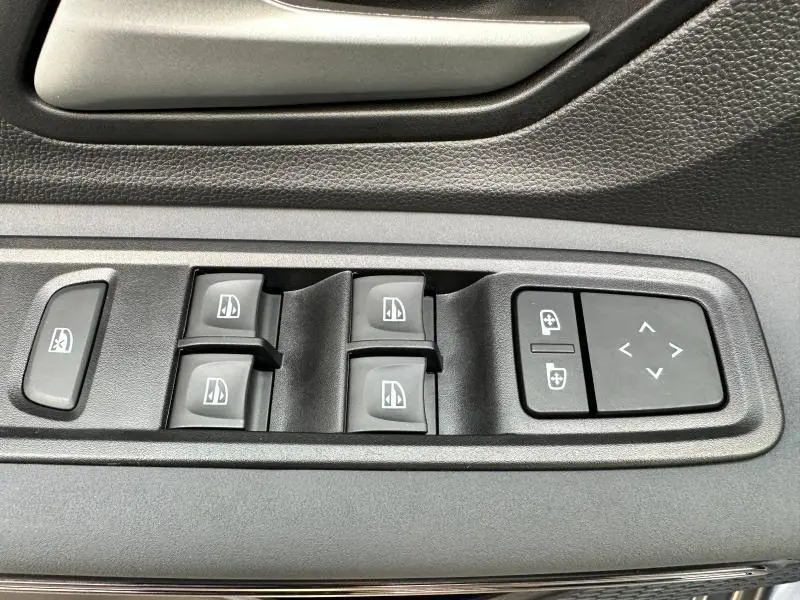 Panneau de commandes des vitres électriques et réglages des rétroviseurs côté conducteur du Dacia Sandero Stepway gris Schiste métallisé 2025.