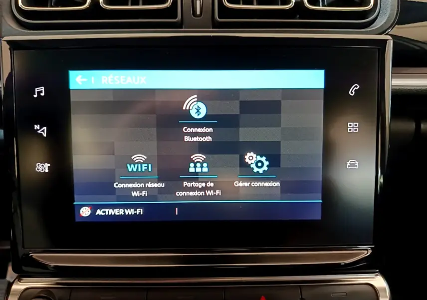 Écran tactile central affichant les options réseau Wi-Fi et Bluetooth dans le tableau de bord d'une Citroën C3 blanche.