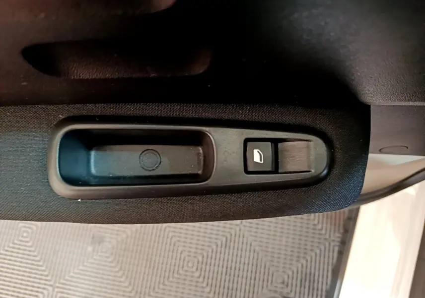 Bouton de commande de lève-vitre côté gauche sur porte intérieure noire d'une Citroën C3 blanche 2019.